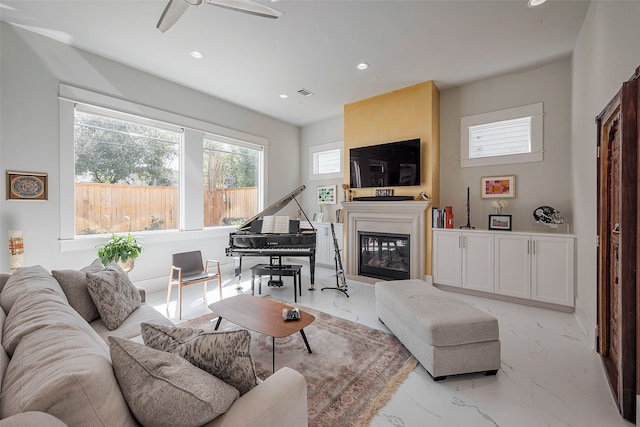 living room with marble finish floor, recessed lighting, visible vents, and a glass covered fireplace