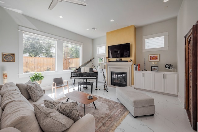 2217 W Main St, Houston, TX 77098 - living area with recessed lighting, light marble finish flooring, a ceiling fan, and a glass covered fireplace