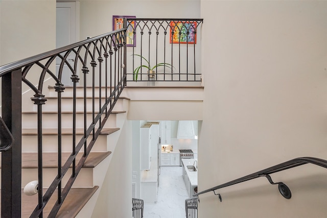 staircase featuring marble finish floor