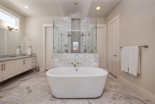 bathroom with marble finish floor, baseboards, a freestanding tub, and vanity