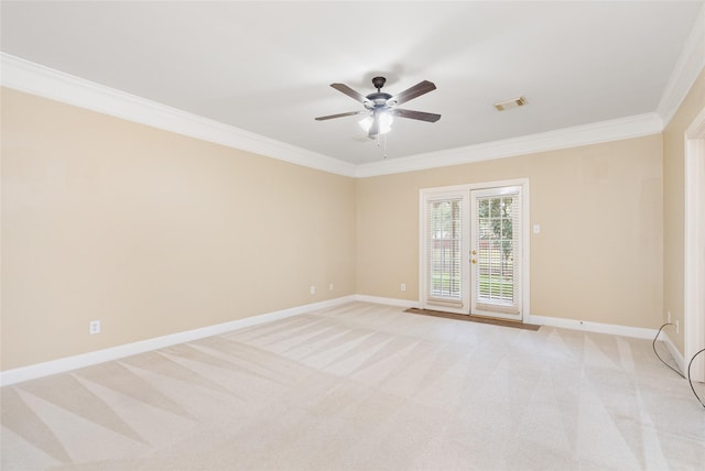 spare room with light colored carpet, visible vents, crown molding, and baseboards