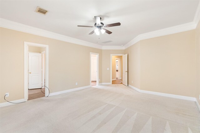 empty room with light carpet, ornamental molding, visible vents, and baseboards