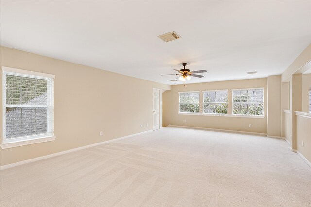 empty room with visible vents, ceiling fan, light carpet, and baseboards