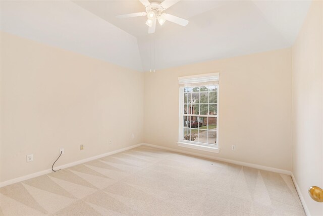 spare room featuring lofted ceiling, baseboards, a ceiling fan, and light colored carpet