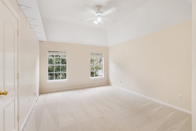 carpeted empty room with ceiling fan, lofted ceiling, and baseboards