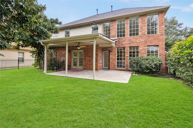 back of house with brick siding, fence, a lawn, and a patio