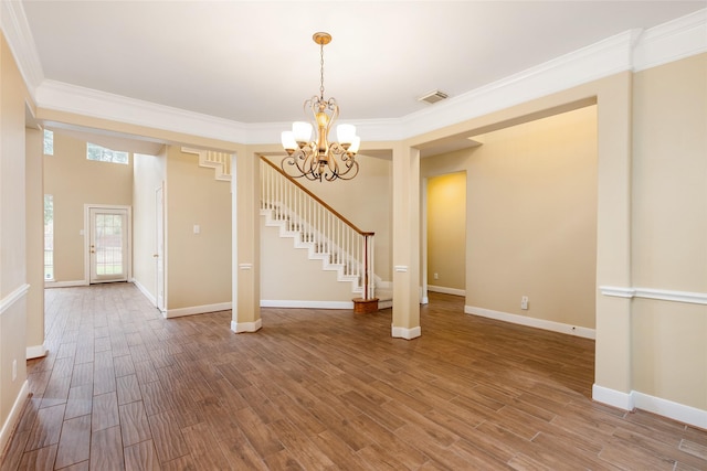 interior space with stairs, wood finished floors, visible vents, and crown molding