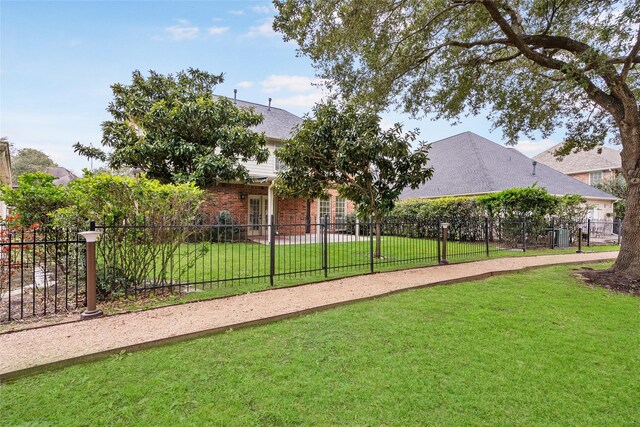 view of community featuring a lawn and fence