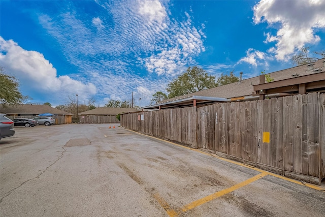 uncovered parking lot featuring fence