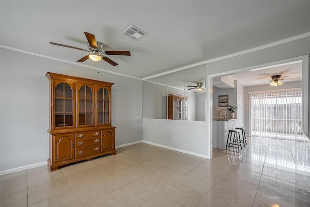 spare room featuring light tile patterned floors, baseboards, visible vents, and ornamental molding