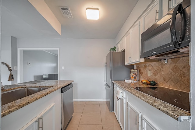 kitchen with visible vents, decorative backsplash, white cabinets, a sink, and black appliances