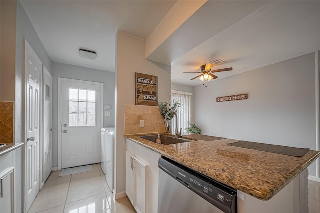 kitchen with washer and clothes dryer, a peninsula, a healthy amount of sunlight, stainless steel dishwasher, and a sink