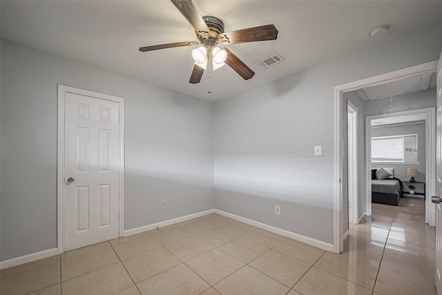 empty room with attic access, visible vents, baseboards, and light tile patterned flooring