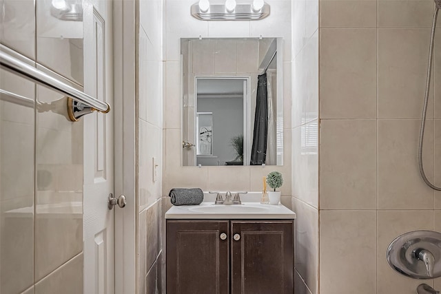 bathroom with walk in shower, vanity, and tile walls