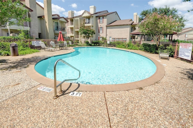 pool featuring a residential view, fence, and a patio