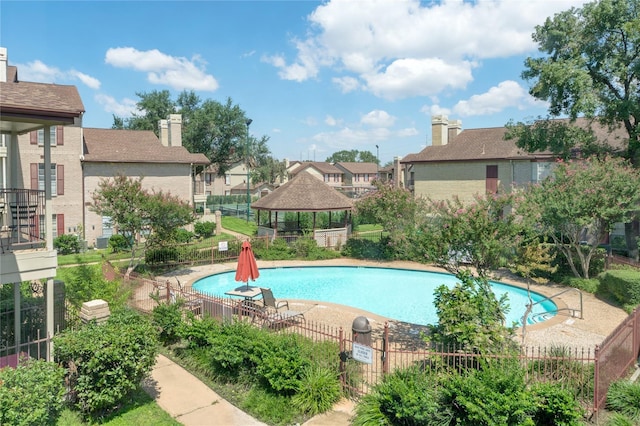 community pool featuring a residential view, fence, a patio, and a gazebo