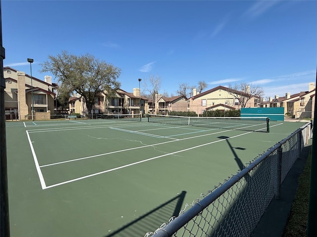 view of sport court featuring fence and a residential view