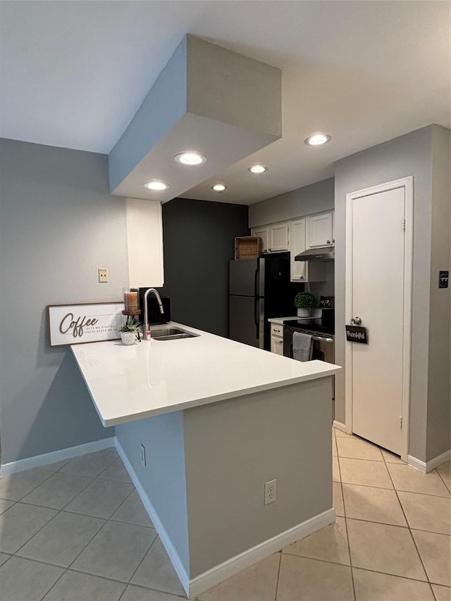 kitchen featuring light tile patterned floors, under cabinet range hood, stainless steel appliances, a peninsula, and a sink