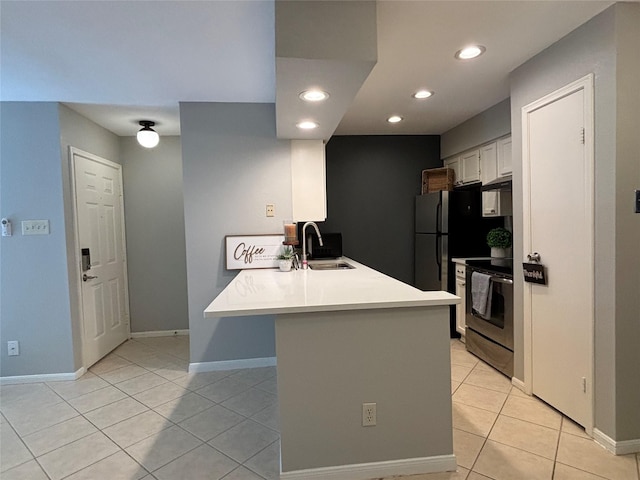 kitchen with light tile patterned flooring, a peninsula, a sink, light countertops, and electric range oven