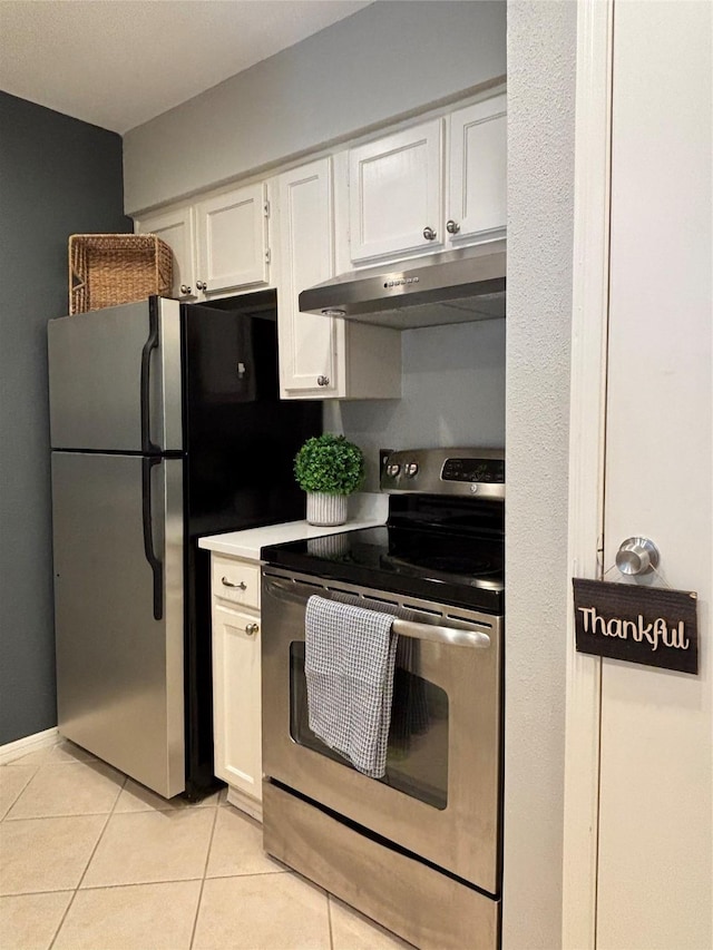 kitchen featuring appliances with stainless steel finishes, light countertops, under cabinet range hood, white cabinetry, and light tile patterned flooring