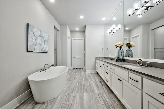 bathroom featuring double vanity, a sink, and baseboards