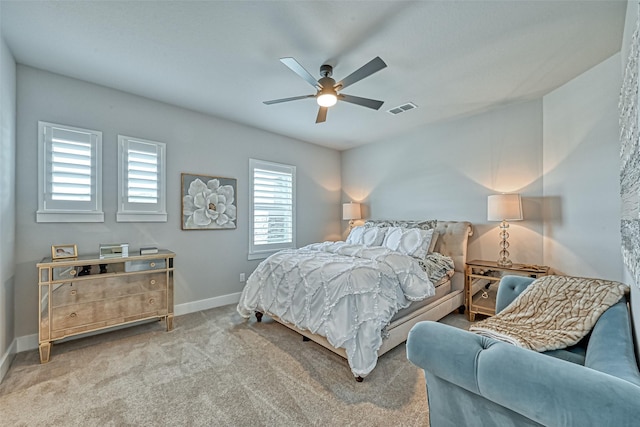 carpeted bedroom featuring ceiling fan, visible vents, and baseboards