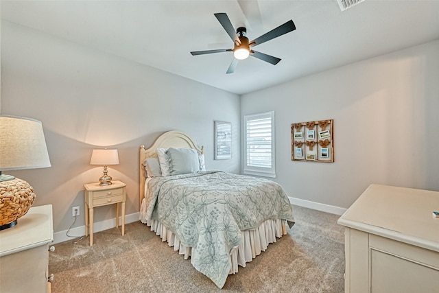 bedroom with light carpet, ceiling fan, visible vents, and baseboards