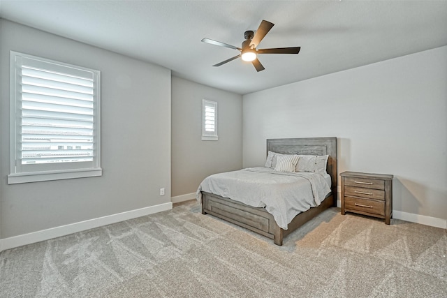 bedroom featuring light colored carpet, ceiling fan, and baseboards