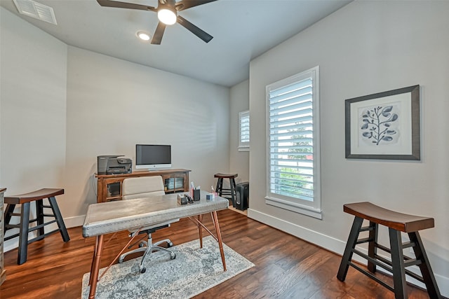 office space featuring dark wood-style floors, visible vents, ceiling fan, and baseboards