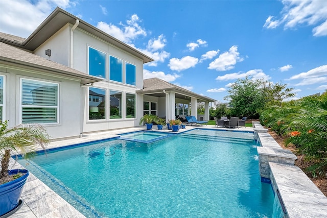 view of pool with a patio area and a pool with connected hot tub