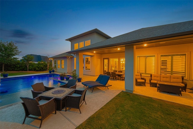 outdoor pool featuring an outdoor living space with a fire pit, a patio, and a lawn