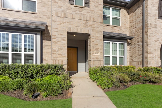 view of exterior entry with brick siding