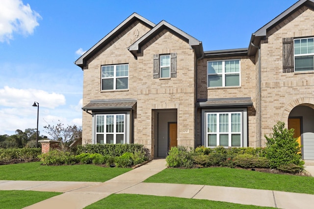 view of front of home featuring brick siding and a front lawn