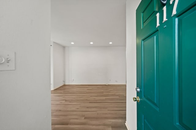 foyer entrance with baseboards, wood finished floors, and recessed lighting