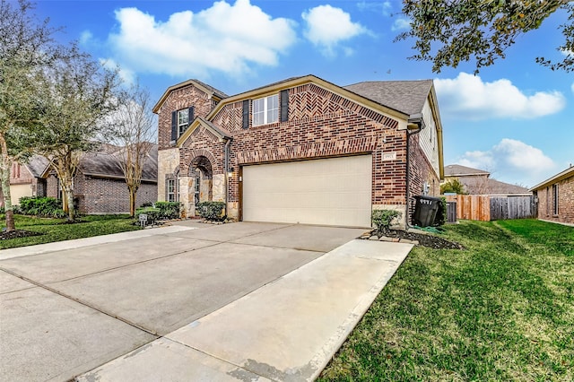 traditional-style home with brick siding, an attached garage, a front yard, fence, and driveway