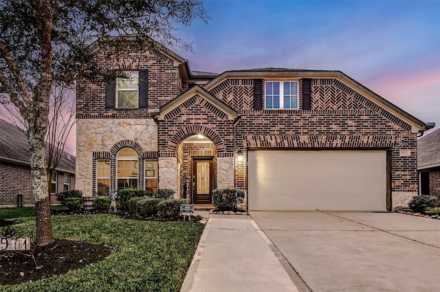 view of front of home featuring a garage, driveway, brick siding, and stone siding