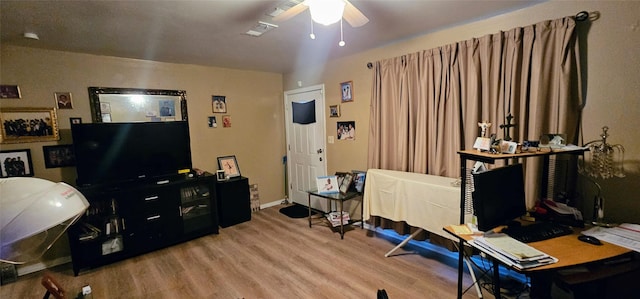 interior space with ceiling fan, visible vents, and wood finished floors