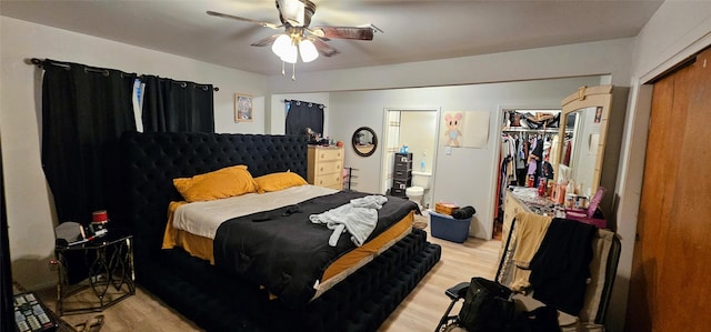 bedroom with a closet, connected bathroom, light wood finished floors, and ceiling fan