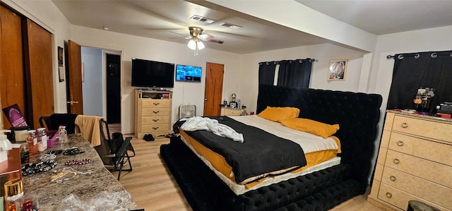 bedroom with visible vents, light wood-style flooring, and a ceiling fan