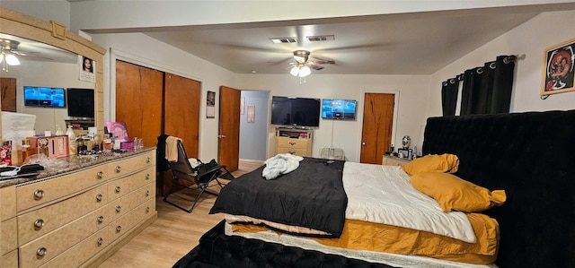 bedroom featuring light wood-style flooring, a closet, visible vents, and a ceiling fan