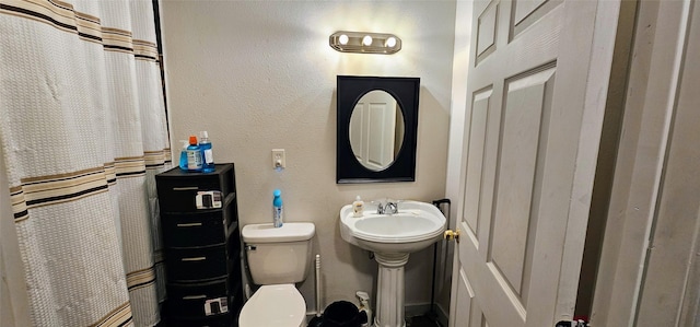 bathroom with toilet, a shower with curtain, and a textured wall