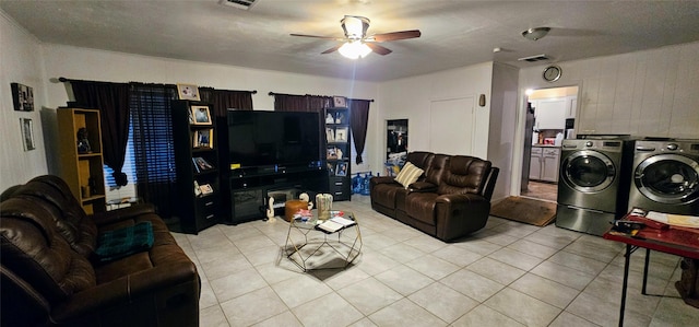 living room featuring light tile patterned floors, ceiling fan, independent washer and dryer, and visible vents