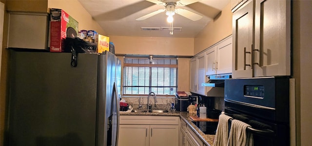 kitchen featuring under cabinet range hood, a sink, visible vents, a ceiling fan, and black appliances