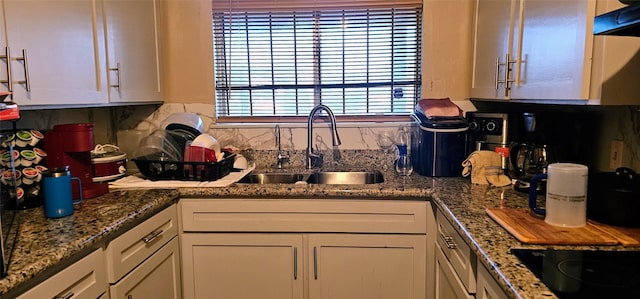 kitchen featuring black electric cooktop, white cabinets, a sink, and exhaust hood