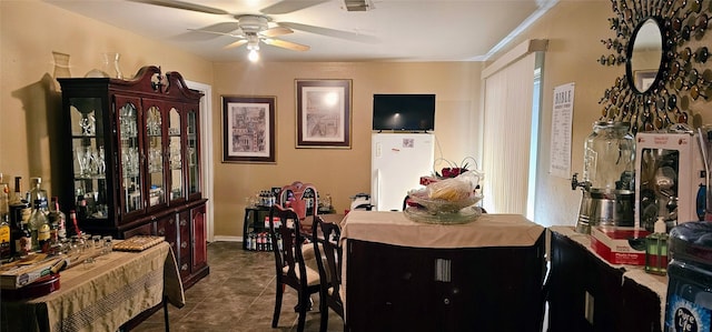 dining space featuring dark tile patterned floors and ceiling fan