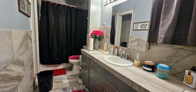 full bath with toilet, a shower with curtain, tile walls, and vanity