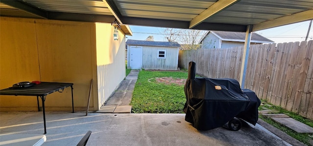 view of patio / terrace with an outdoor structure, a shed, area for grilling, and fence