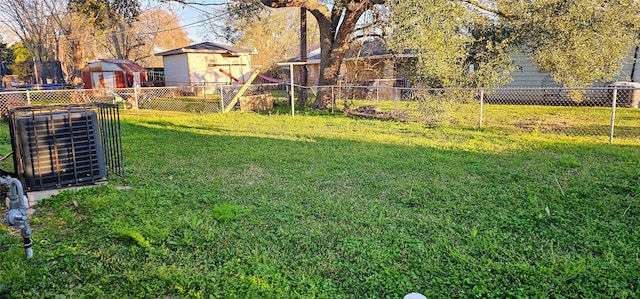 view of yard with an outbuilding, a storage unit, and fence