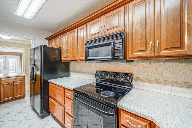 kitchen featuring light tile patterned floors, light countertops, french doors, black appliances, and brown cabinetry