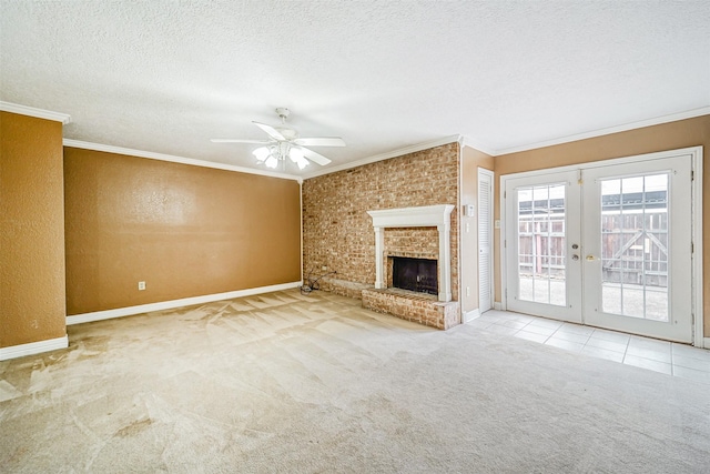 unfurnished living room with french doors, crown molding, a brick fireplace, carpet flooring, and a textured ceiling